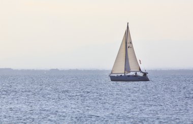 Yelkenli gün batımında yola çıkıyor.