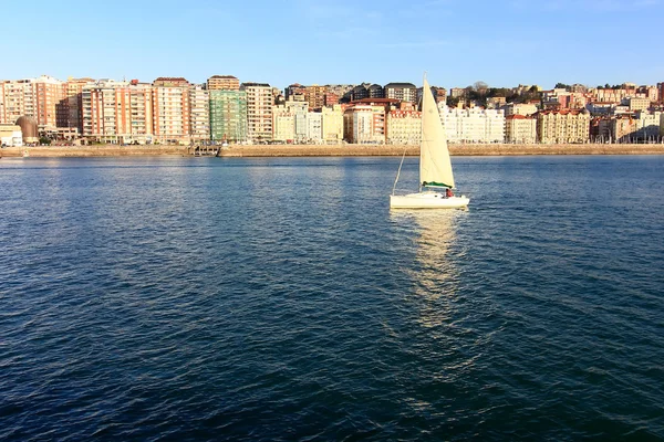 Pequeno veleiro branco navegando em frente à cidade de Santander , — Fotografia de Stock