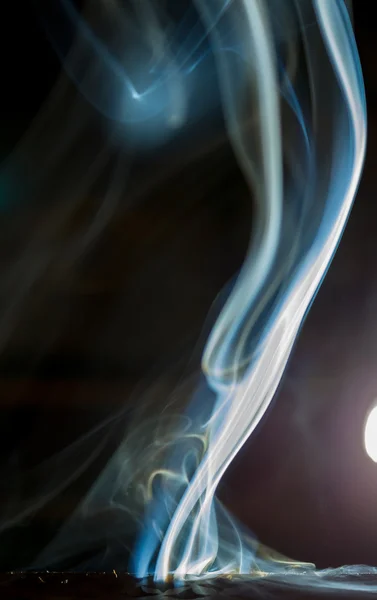 Rook van een wierook aromatische formulieren op een zwarte achtergrond maken — Stockfoto