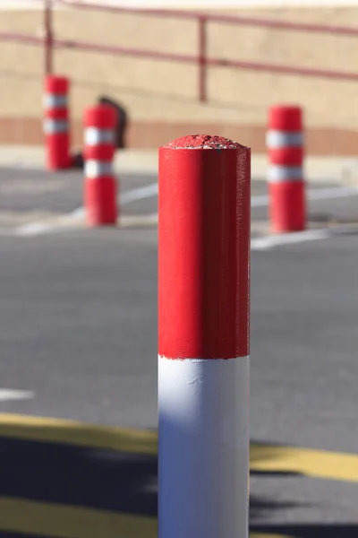 Iron bollards red and white going over cars — Stock Photo, Image