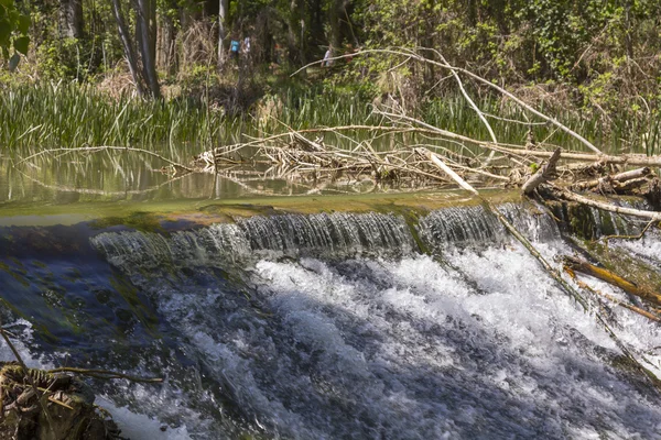 Agua clara en cascada ligera en un río tranquilo — Foto de Stock