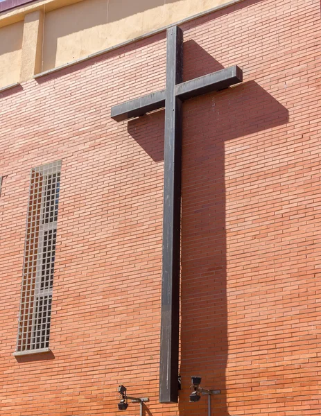 Large iron cross on the facade of a Catholic church — Stock Photo, Image