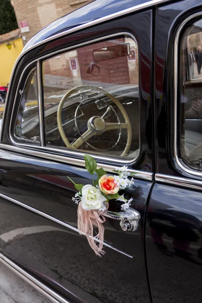 Цветы, украшающие старый черный роскошный автомобиль — стоковое фото