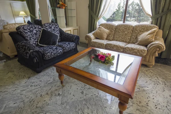 Elegantes sofás antigos, mesa de vidro com flores e relaxante — Fotografia de Stock