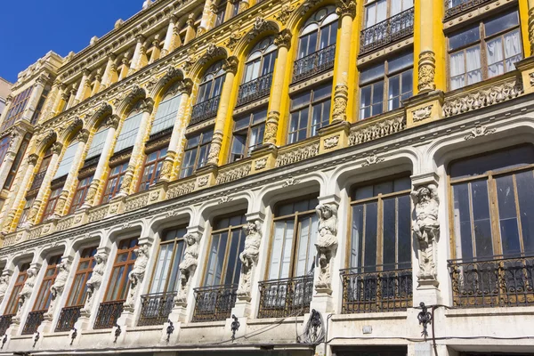 Edifício velho agradável com fachada altamente decorada e janelas grandes — Fotografia de Stock