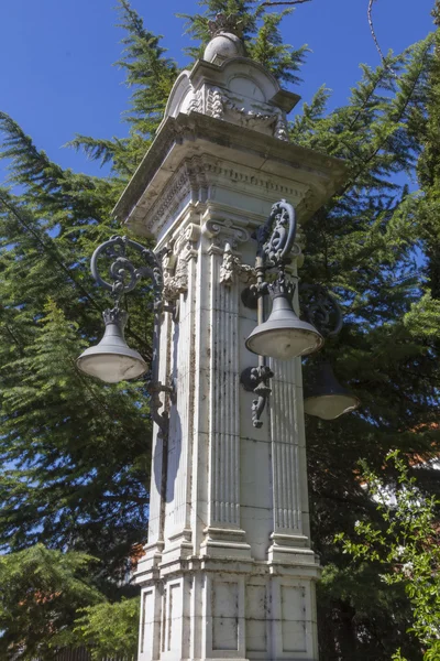Streetlights on ancient decorated stone column — Stock Photo, Image