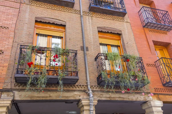 Varandas com flores em uma antiga casa de tijolo — Fotografia de Stock