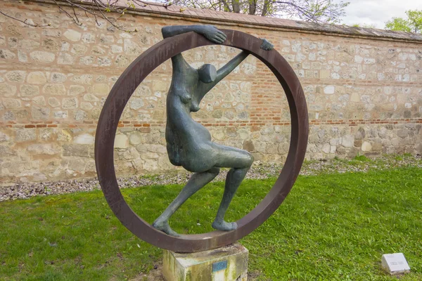 Abstract sculpture nude woman inside an iron ring — Stock Photo, Image