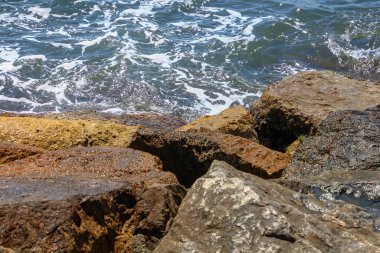 Deniz dalgaları kıyıdaki kayalara ulaşıyor.