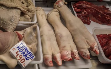 Pamplona, İspanya 'da bir kasapta çiğ domuz paçası ve dana burnu.