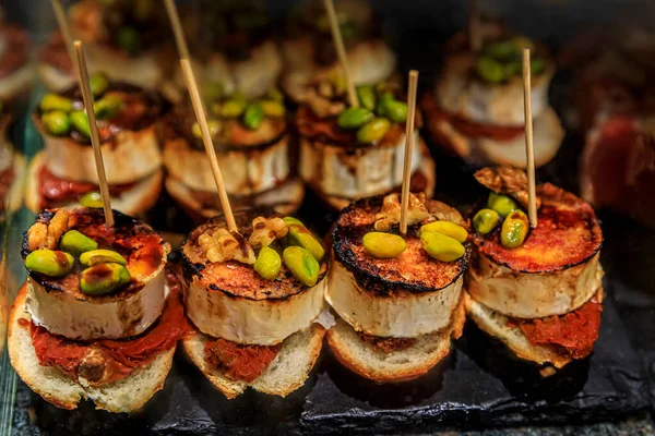 Pintxos with goat cheese, nuts and red pepper in a bar in San Sebastian, Spain — Stock Photo, Image