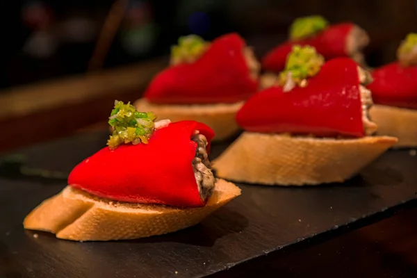 Rode piquillo paprika 's gevuld met tonijn pintxos in een bar in San Sebastian, Spanje — Stockfoto