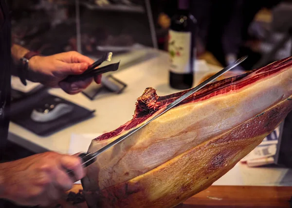 Leg of serrano iberico ham carved at a butcher shop in San Sebastian, Spain — Stock Photo, Image