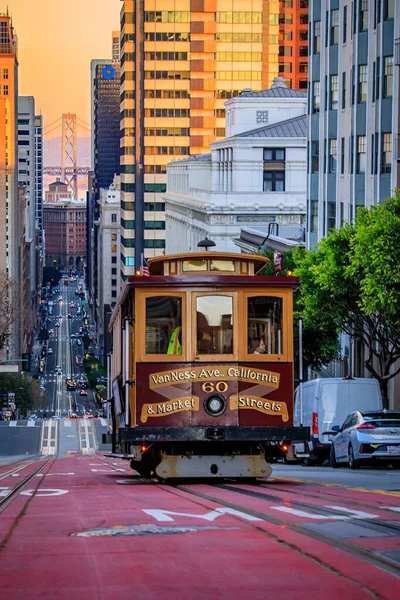 Kaliforniya caddesinde güneş batarken Bay Bridge ile ünlü bir teleferik manzarası.
