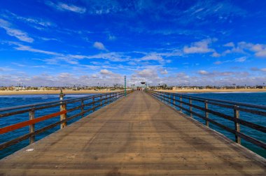 Pacific ocean waves at the beach in a famous tourist destination viewed from Seal Beach pier in California, USA
