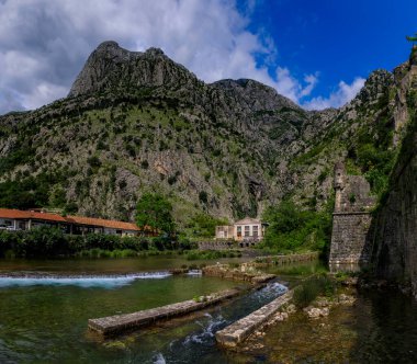 Kotor Körfezi 'nin zümrüt yeşili suları veya Boka Kotorska, dağlar ve eski Kotor kasabasının antik taş şehir duvarı Karadağ' daki eski Venedik kalesi