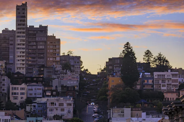 位于旧金山著名的弯曲的伦巴德街的高角形房屋景观 日落时天空火热 长期暴露 — 图库照片