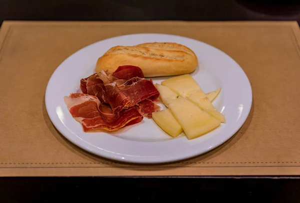 西班牙潘普洛纳一家餐馆的早餐盘 上面有面包 奶酪和西班牙色拉诺意大利火腿 — 图库照片