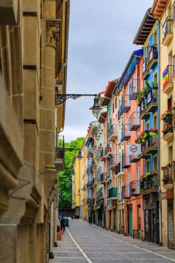 Pamplona, İspanya - 24 Haziran 2021: Eski kasabadaki renkli yüzler ve süslü metal balkonlar veya boğaların koşusuyla ünlü Casco Viejo