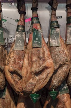 Pamplona, İspanya - 20 Haziran 2021: İspanyol serrano iberico jambonu eski kasabadaki bir kasapta ya da Casco Viejo 'da sergileniyor