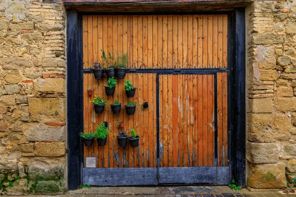 Oude houten poort met bloempotten in een oude stenen gevel in Olite, Spanje — Stockfoto