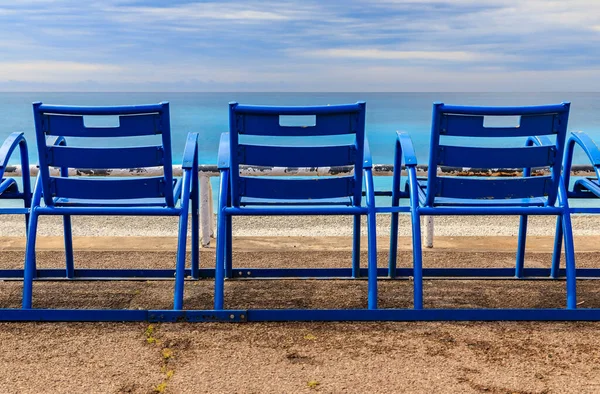 Mediterranean Sea and famous blue chairs on Promenade des Anglais on a cloudy day in Nice, Cote d\'Azur, France
