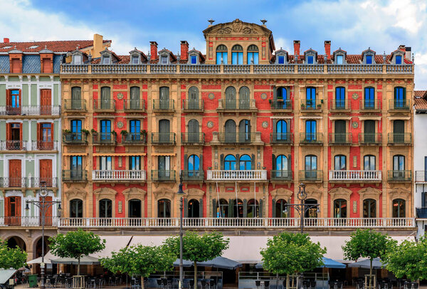 Ornate facades of buildings on Historic Plaza del Castillo with restaurants and cafes in Old Town Pamplona, Spain famous for running of the bulls