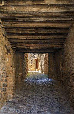 Old stone houses and narrow arched passage in a picturesque medieval village of Ujue in the Basque Country, Navarra, Spain