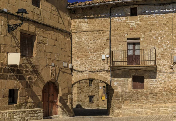 Old stone houses on cobblestone Plaza Mayor in a picturesque medieval village of Ujue in the Basque Country, Navarra, Spain