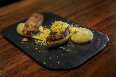 Spanish pintxos of deconstructed seared foie gras toast with a truffle cream in a restaurant, San Sebastian Donostia, Basque Country, Spain