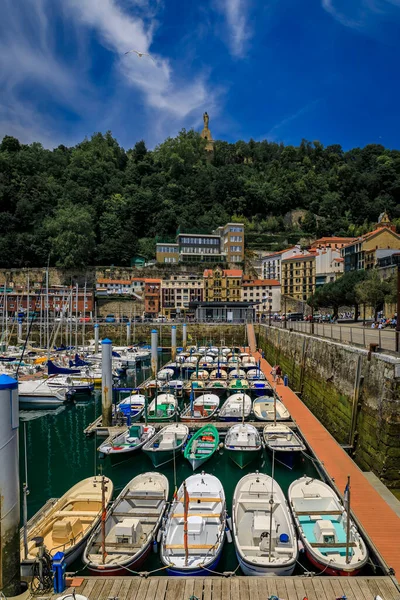 View of colorful fishing boats on La Concha bay with Monte Urgull in the background in San Sebastian Donostia, Basque Country, Spain