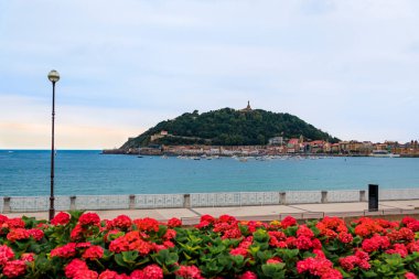 View of La Concha bay and mount Urgull, San Sebastian Donostia at sunset with the city coastline and waterfront homes, Basque Country, Spain