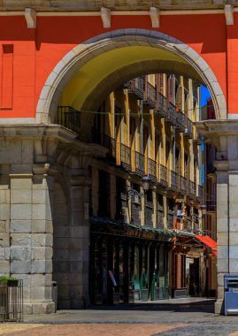 İspanya 'nın Madrid şehrinde Calle de la Sal manzaralı kemer boyunca kafeler ve restoranlarla çevrili Plaza Mayor kapısı