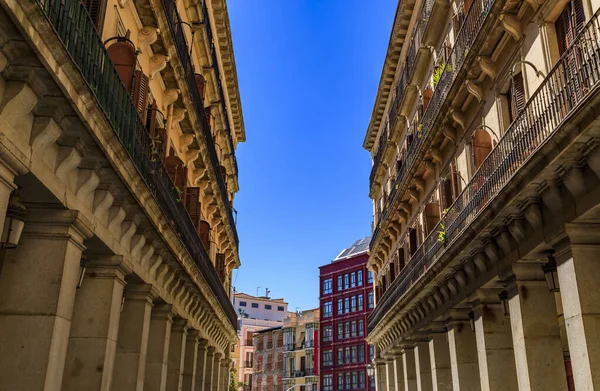 Columns of the building arcade along Calle de Ciudad Rodrigo leading away from Plaza Mayor in Madrid, Spain