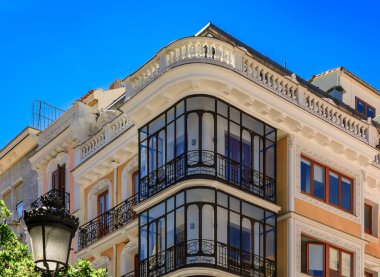 Madrid, İspanya 'da şehir merkezinin bir caddesinde süslü sanat eserleri bulunan yeni metal balkonları olan güzel geleneksel yerleşim yerleri.