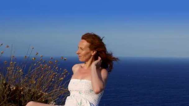 Happy redhead woman feeling wind in high lighthouse — Stock Video