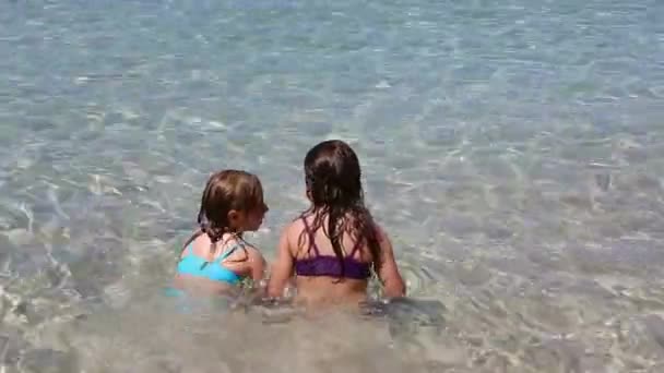 Niñas jugando en la costa de agua de playa en ibiza — Vídeos de Stock