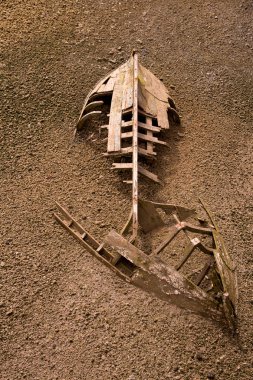 boat ship skeleton half buried in sand clipart