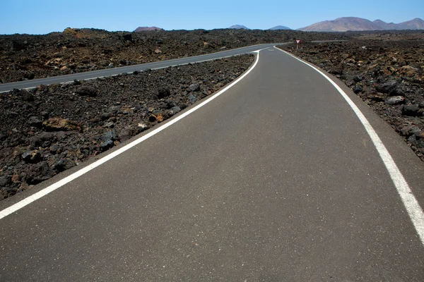 Black volcanic soil and road detail in Lanzarote — Stock Photo, Image