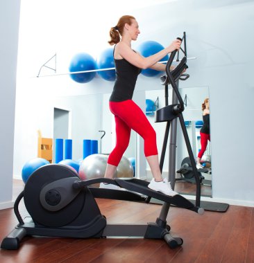 Aerobics cardio training woman on elliptic crosstrainer clipart
