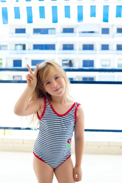 Blond dziecko dziewczynka strój kąpielowy z rąk znak zwycięstwo — Zdjęcie stockowe