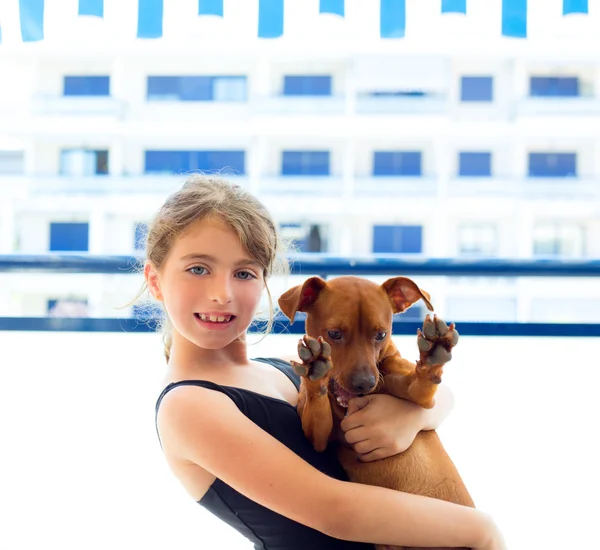 Brunette kid girl in swimsuit playing with dog — Stock Photo, Image