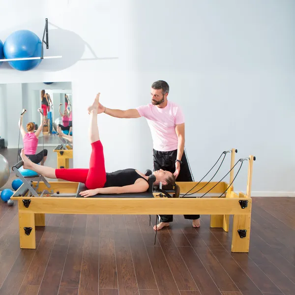 Pilates aerobic personal trainer man in cadillac — Stock Photo, Image