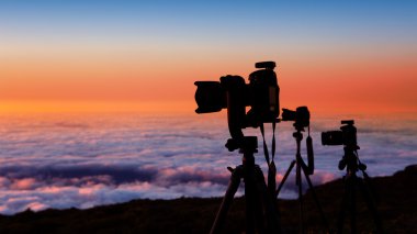 camera tripods photographer sunset sea of clouds clipart