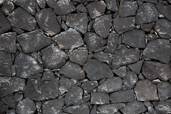 Pierre de lave noire mur de maçonnerie volcanique — Photo