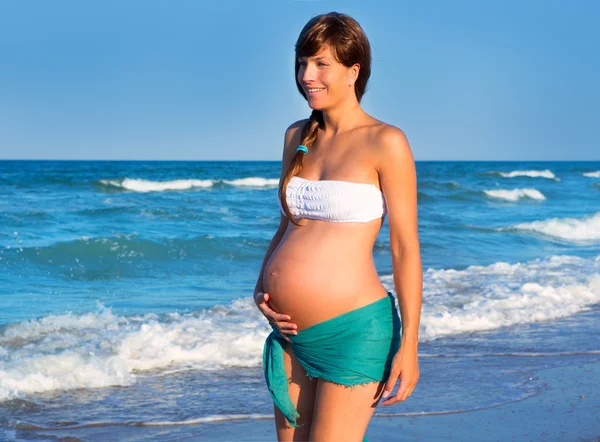 Krásná těhotná žena chůze na modré pláže — Stock fotografie