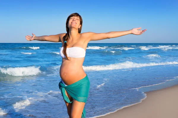 Hermosa mujer embarazada caminando en la playa azul — Foto de Stock