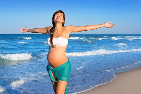 Mooie zwangere vrouw lopen op blauwe strand — Stockfoto