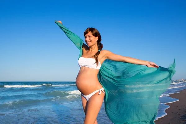 Mooie zwangere vrouw lopen op blauwe strand — Stockfoto