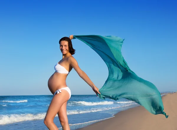 Mooie zwangere vrouw lopen op blauwe strand — Stockfoto